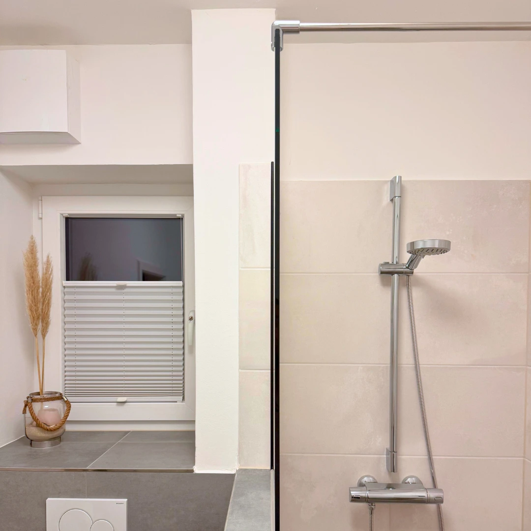 Duschabtrennung aus 8 mm Klarglas auf Mauer