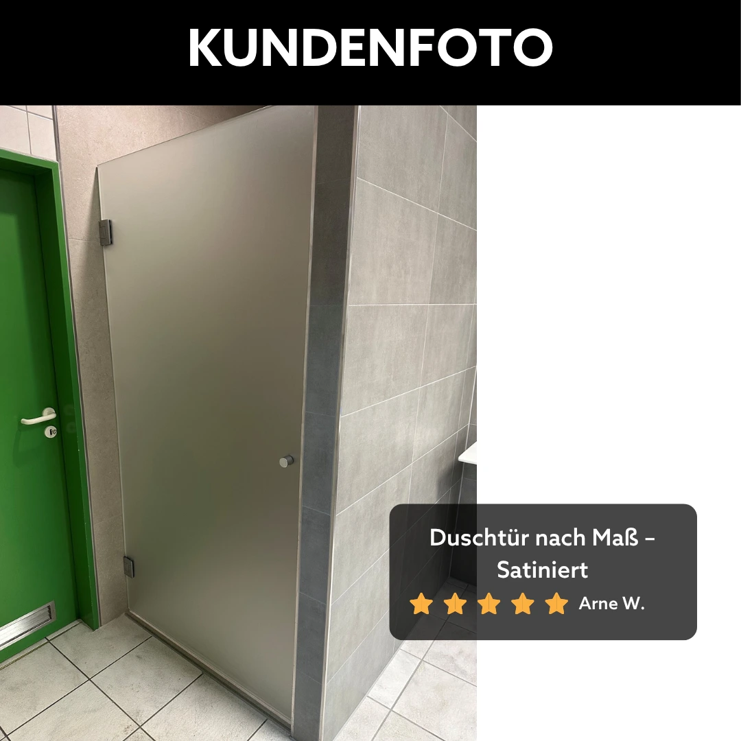 Satinierte Duschtür in einer Badezimmernische mit verchromten Beschlägen