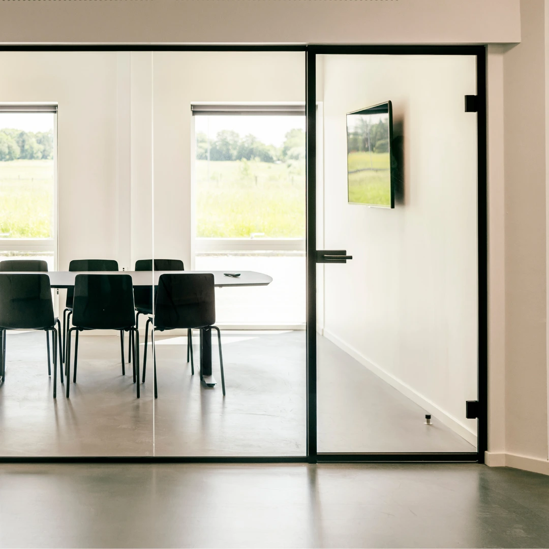Glastrennwandsystem mit Tür und schwarzen Profilen für Besprechungsraum