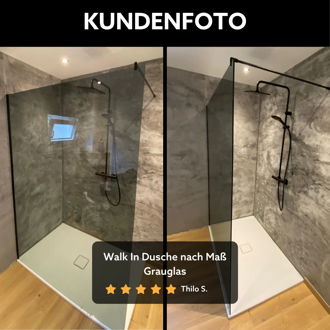 Kundenreferenz einer Walk In Dusche nach Maß aus Grauglas mit schwarzen Beschlägen, moderne bodengleiche Duschlösung mit getöntem Glas und offener Raumwirkung im Badezimmer